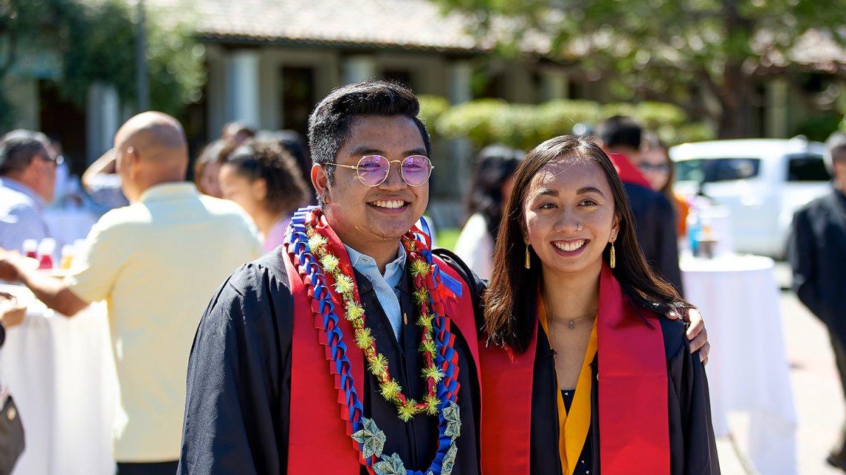 Two graduates posing for a photo after graduation